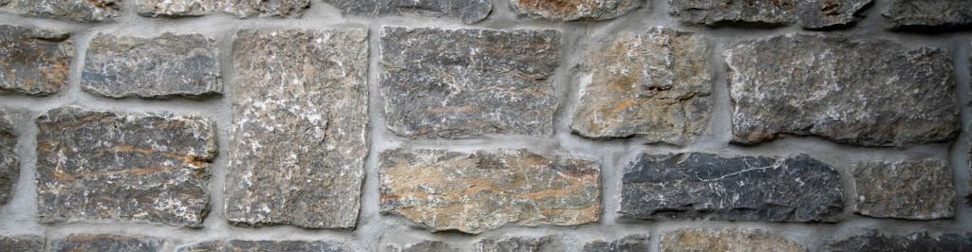 A close-up shot of a vintage stonework wall background. Dunning Stone and Supply provides masonry products
